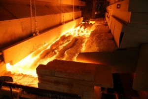 Feeding batches of raw material into the furnace for glass production
